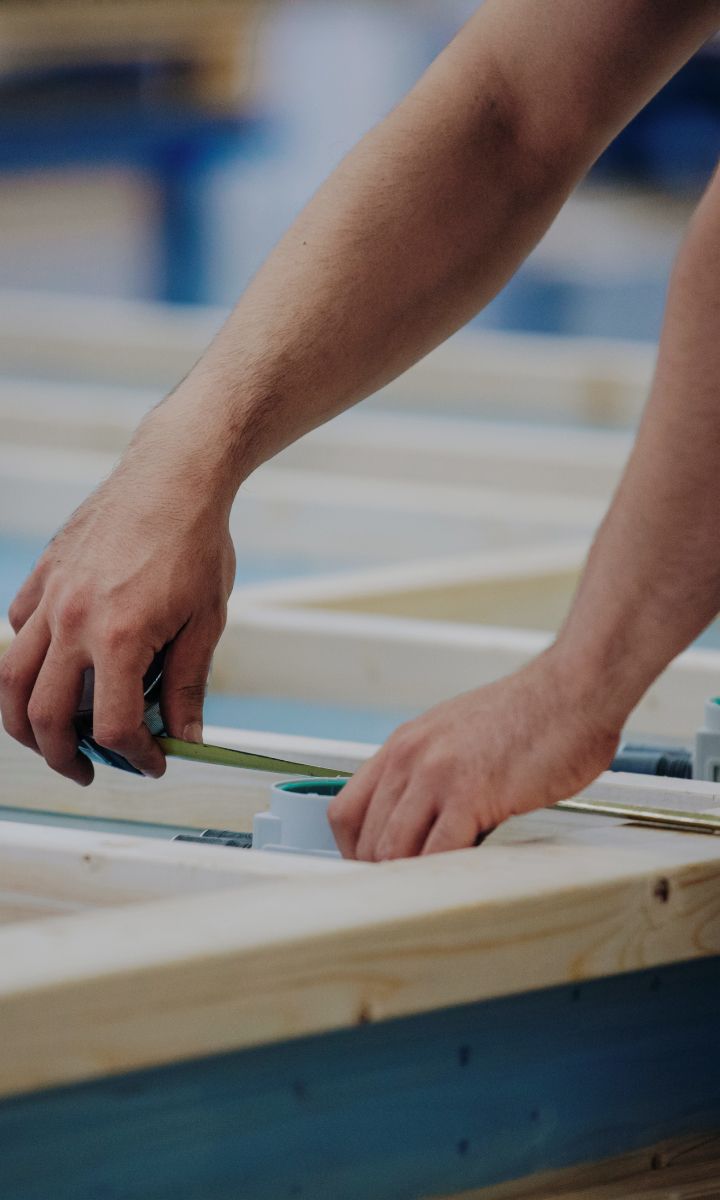 a person measuring some wood