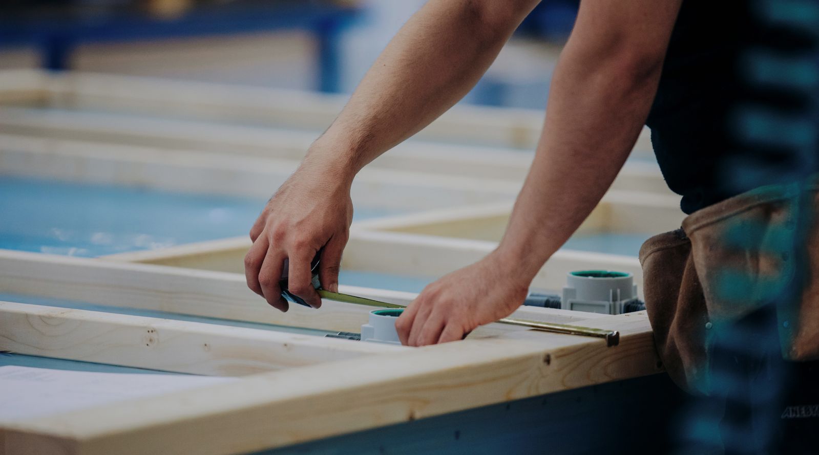 a person measuring some wood