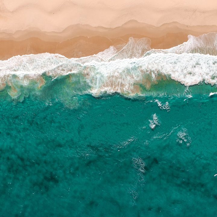 a turquoise sea lapping onto a sandy beach